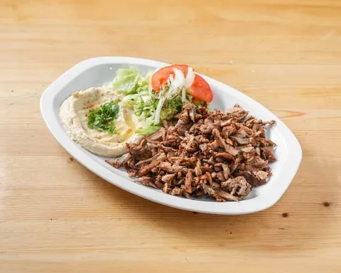 Plato de shawarma con hummus y ensalada