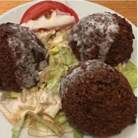 Falafel con salsa blanca sobre lechuga
